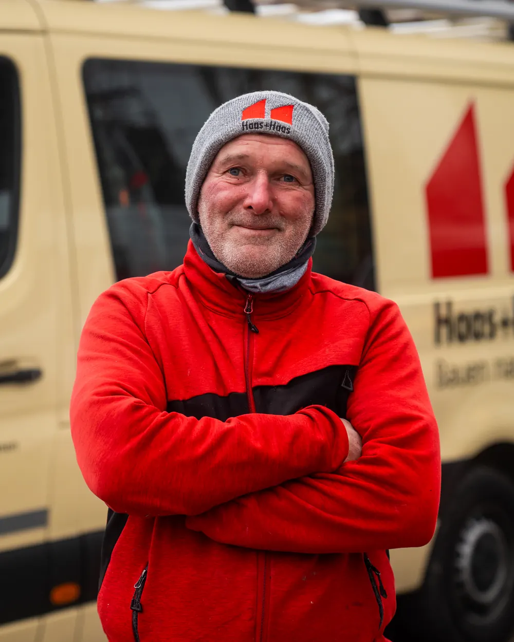 Mitarbeiter von Haas & Haas in Firmenjacke vor dem Firmenbus